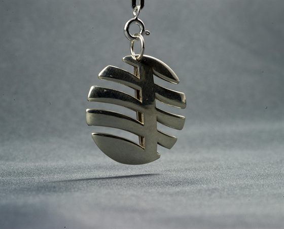 Pendentif plat en métal, découpé de fentes parallèles
